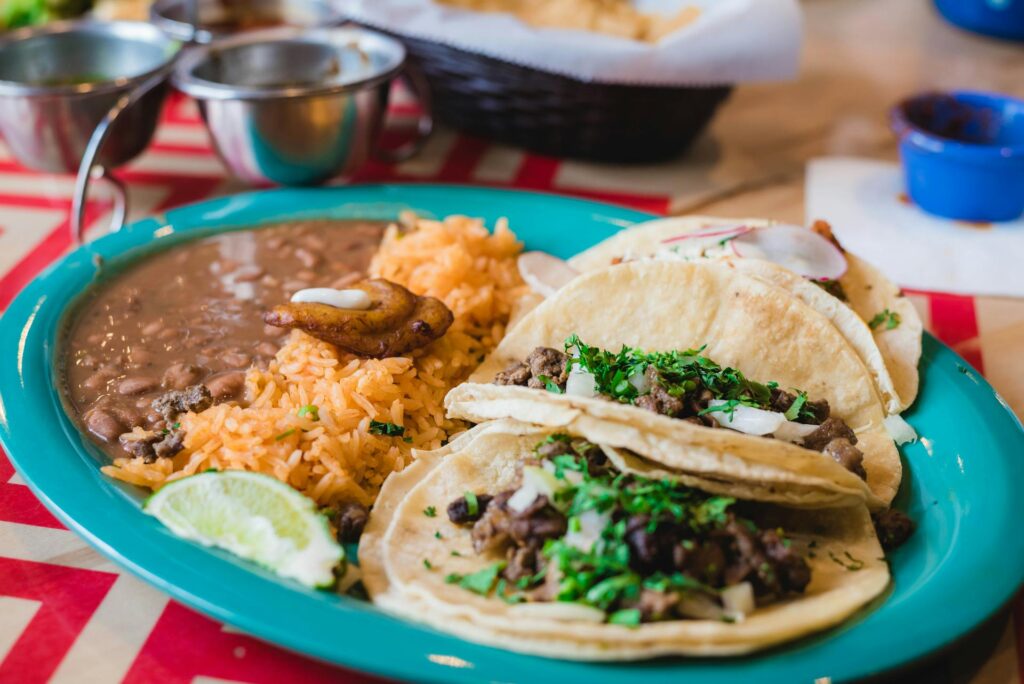Tacos on a plate with beans and rice